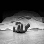 The dead man's body. Focus on hand