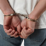 Man in handcuffs behind his back.