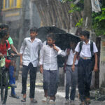 School students return from their school during heavy rain in Siliguri, India, on August 12, 2025. Continuous rainfall in these parts and nearby hills causes a heavy impact on normal life, with several landslides and waterlogging in the streets. (Photo by Diptendu Dutta/NurPhoto via Getty Images)