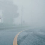 foggy rural asphalt highway perspective with white line, misty road, Road with traffic and heavy fog, bad weather driving
