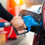 Refueling the car at a gas station fuel pump. Man driver hand refilling and pumping gasoline oil the car with fuel at he refuel station. Car refueling on petrol station. Fuel pump at station
