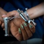 Close-up of woman hand with Indian handcuffs and key