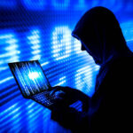 hooded adult man cyber criminal