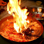 A close-up of a sacred fire (Havan Kund) burning with bright flames during a Hindu puja ritual