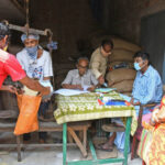 Burdwan Town, West Bengal / India - 02.05.2020: People in a queue to collect food grains at a ration shop in Burdwan town during the lock down period due to Novel Coronavirus (COVID-19) outbreak. At Burdwan Town, Purba Bardhaman District, West Bengal, India.